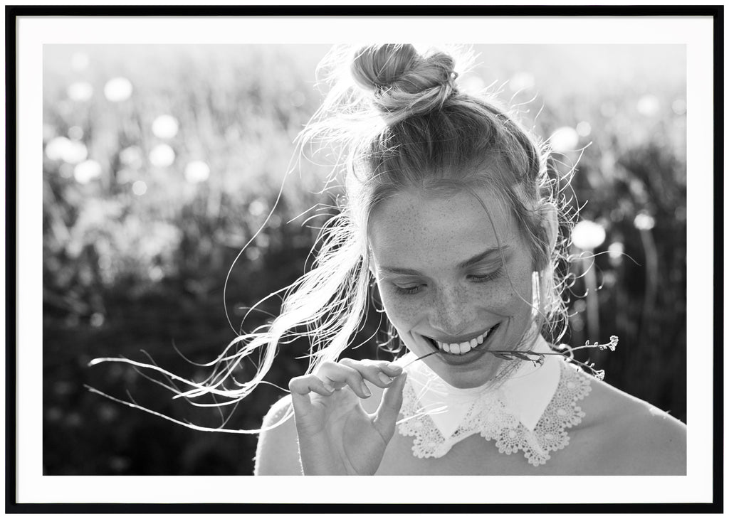 Black and white photograph of a woman whose hair is tied in a knot. Black frame. 