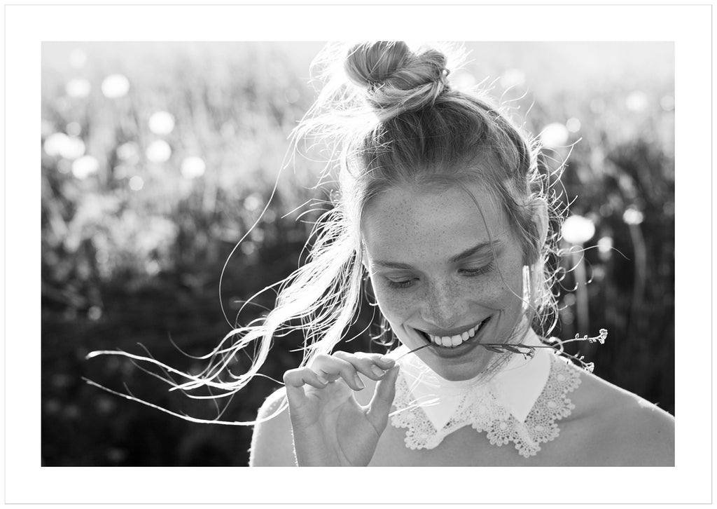 Black and white photograph of a woman whose hair is tied in a knot.
