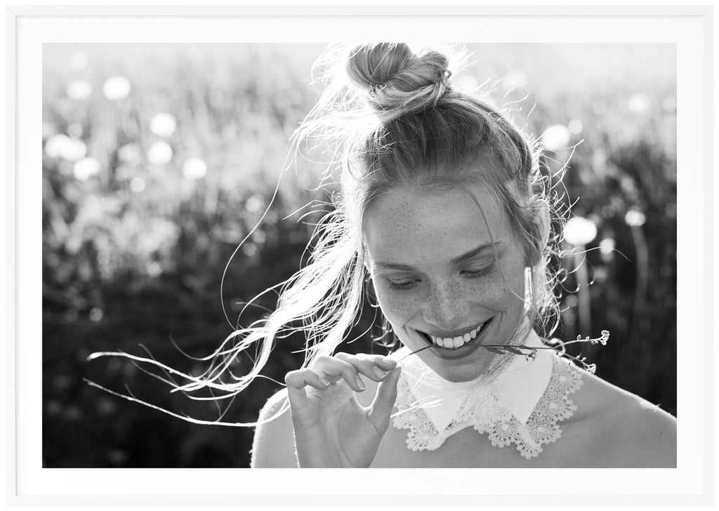 Black and white photograph of a woman whose hair is tied in a knot. White frame. 