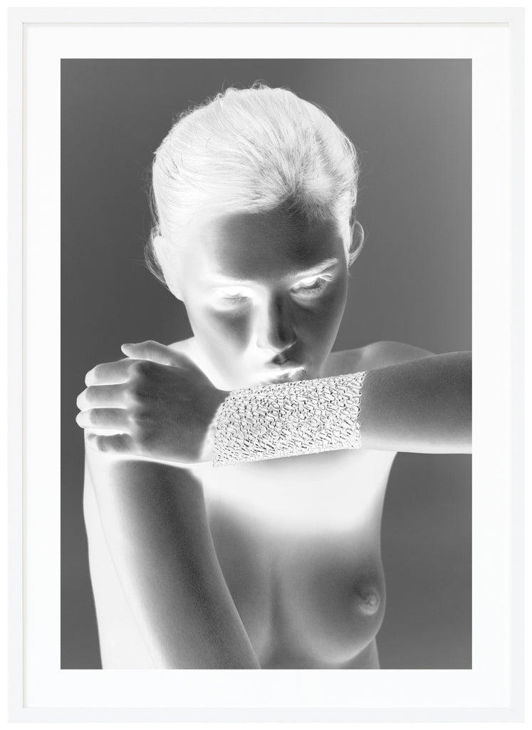  Black and white fashion photography with special effect of a naked woman wearing only an exclusive gold bracelet. White frame. 