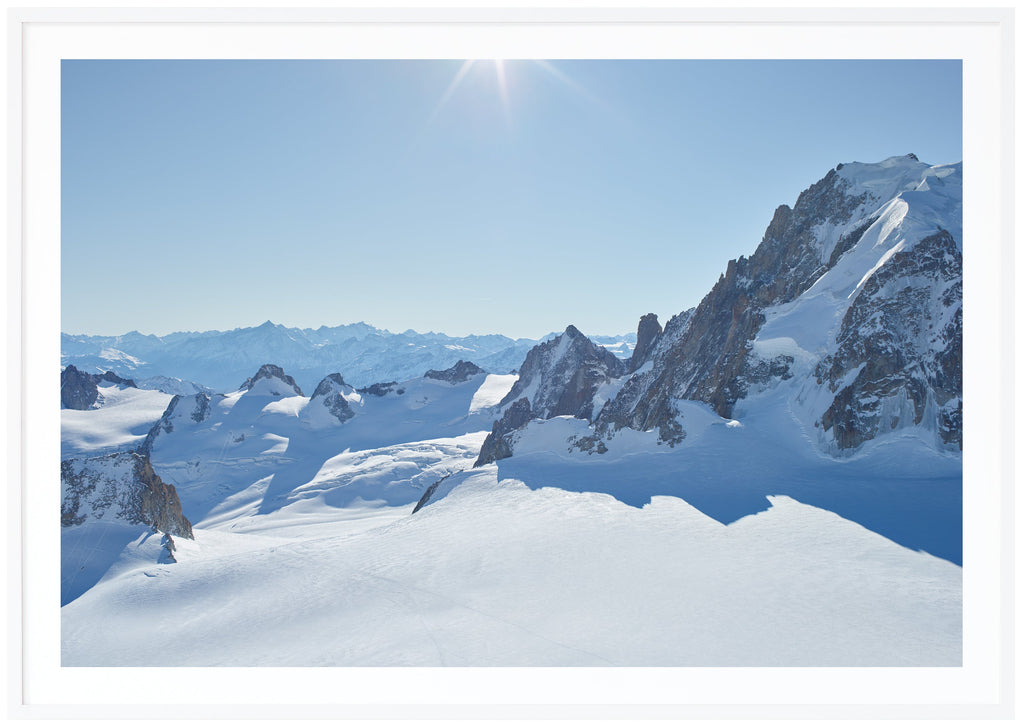 Color photography of snow-capped Alps in panorama. White frame. 