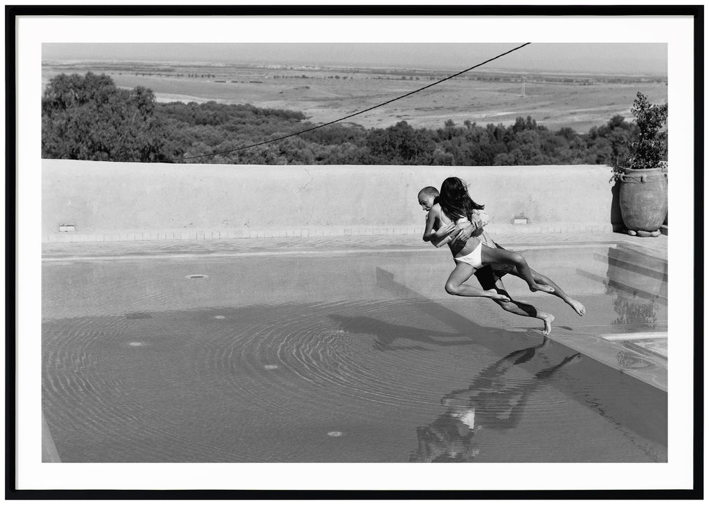 Love couple throwing themselves in a pool. Taken in Morocco by Patrik Sehlstedt.  Black frame. 