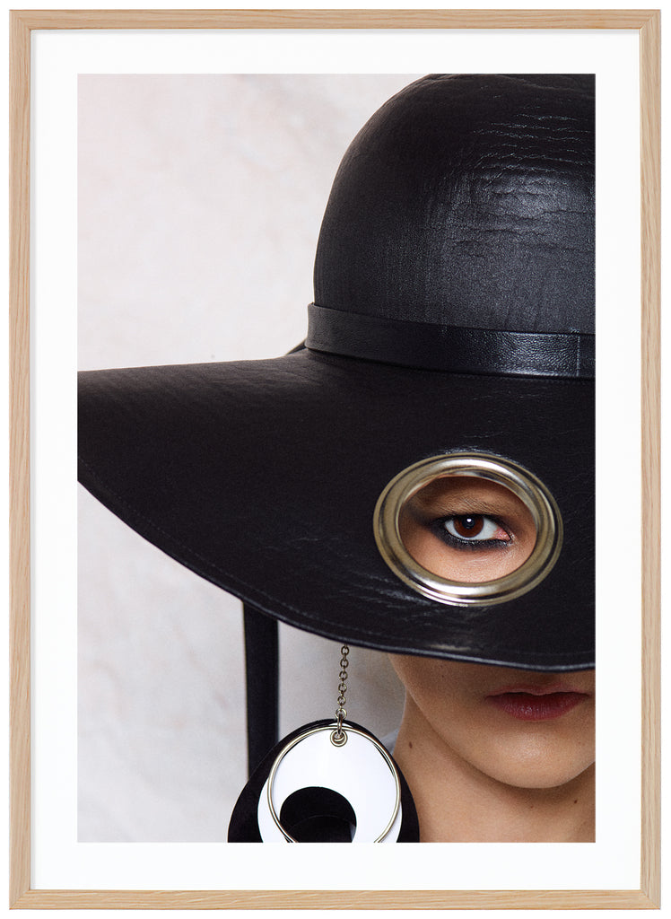 Poster of woman with big black hat. White background. Oak frame.