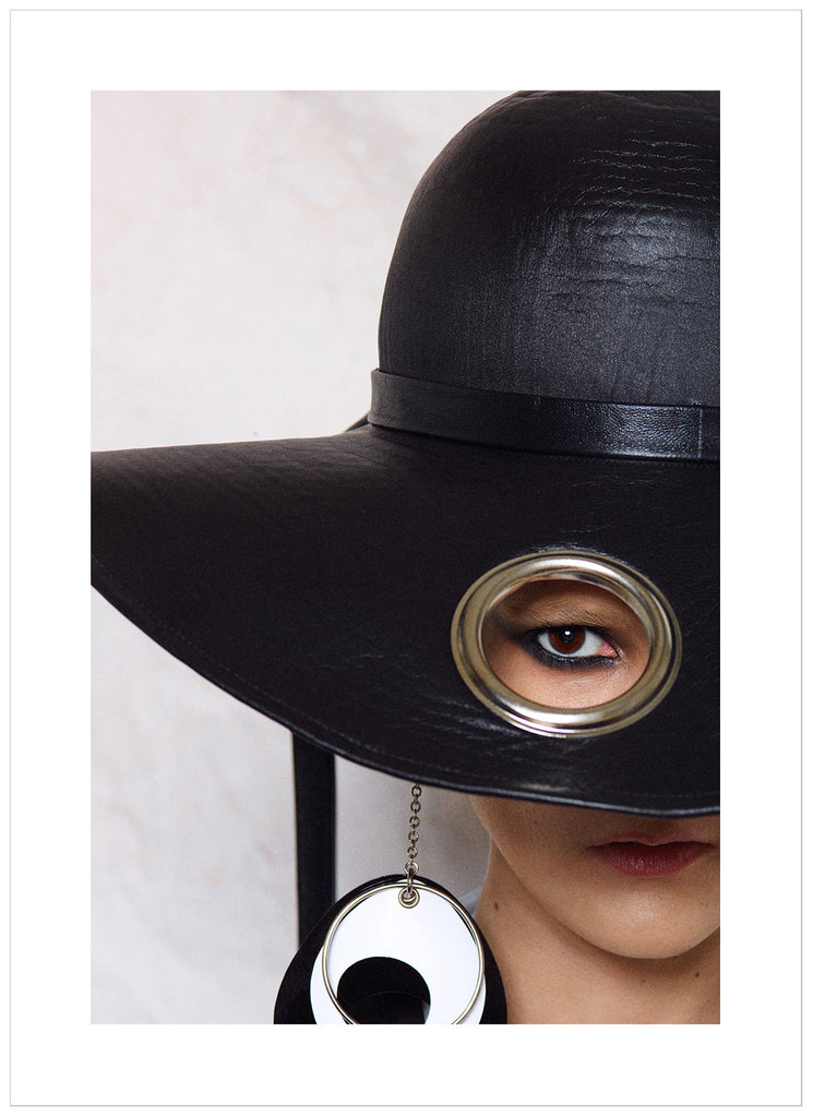 Poster of woman with big black hat. White background.