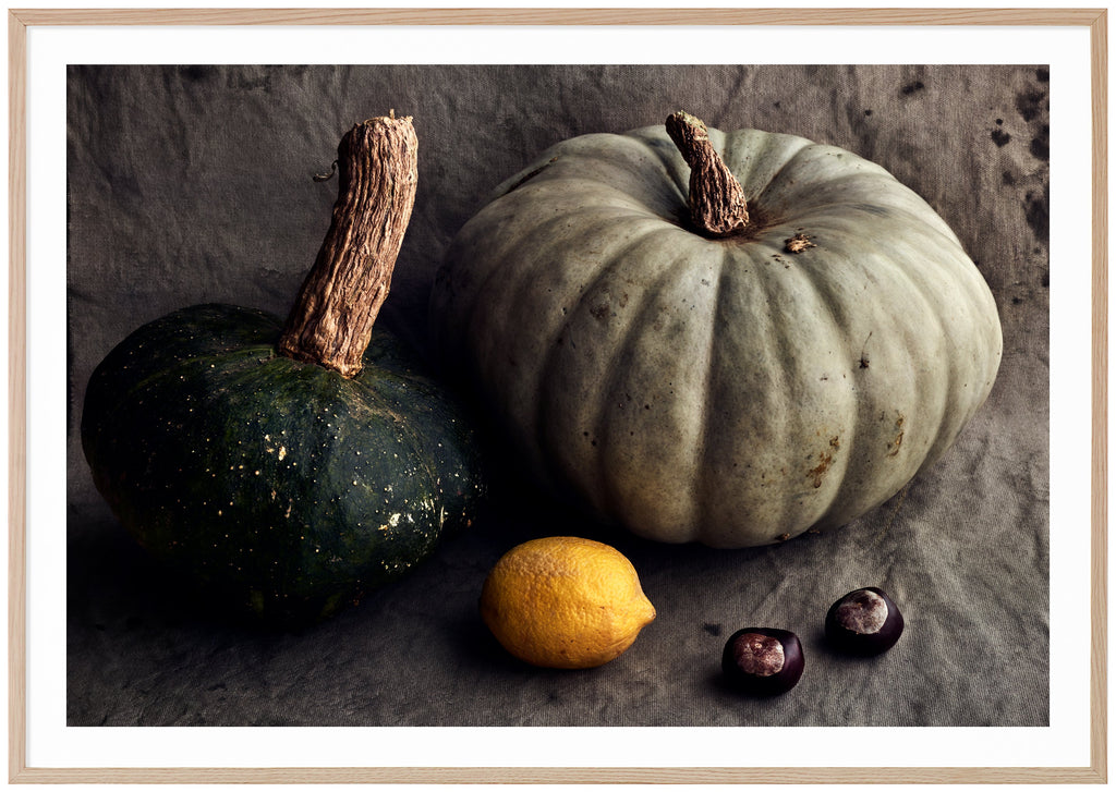 Still life in the color of a pumpkin, lemon and chestnuts. Oak frame. 