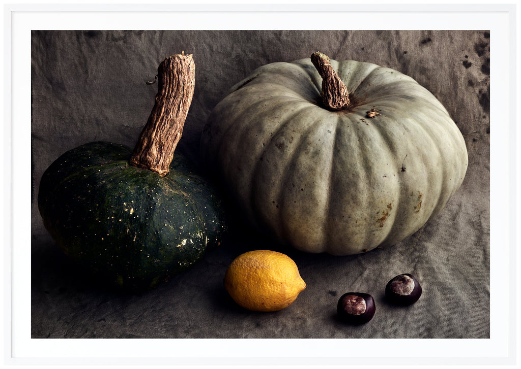 Still life in the color of a pumpkin, lemon and chestnuts. White frame. 