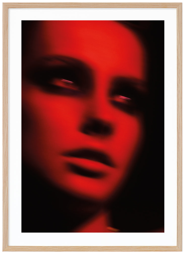 Photograph in the tones red and black, by a woman in black makeup around the eyes. Oak frame.