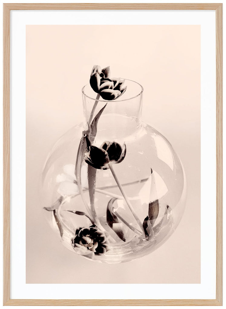 Graphic photo art of a glass vase with a number of tulips that have collapsed in it.  Oak frame.