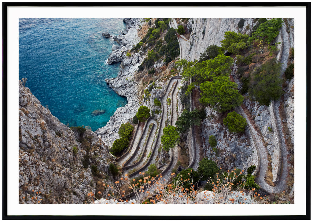 Color photography of a view of a stone promenade on the Italian island of Capri. Black frame. 