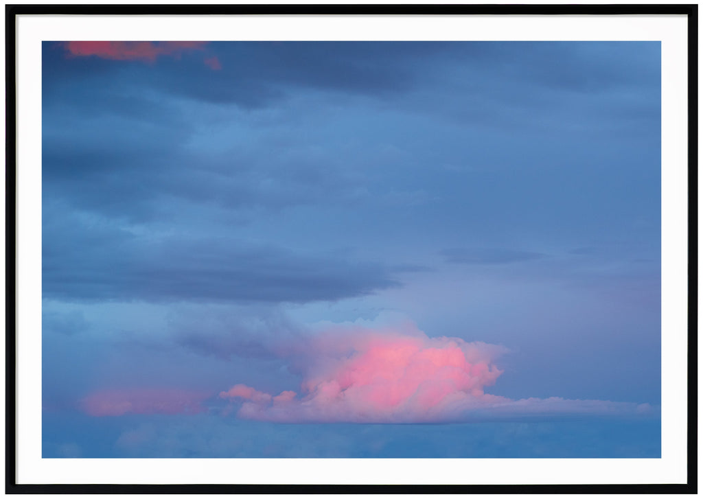 Photography of clouds in colors blue with some pink tones.  Black frame.