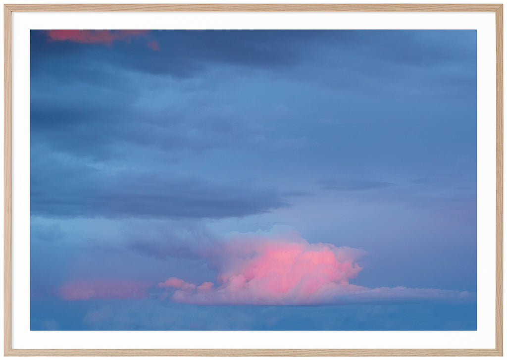 Photography of clouds in colors blue with some pink tones.  Oak frame. 