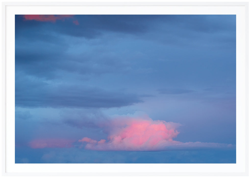 Photography of clouds in colors blue with some pink tones.  White frame. 